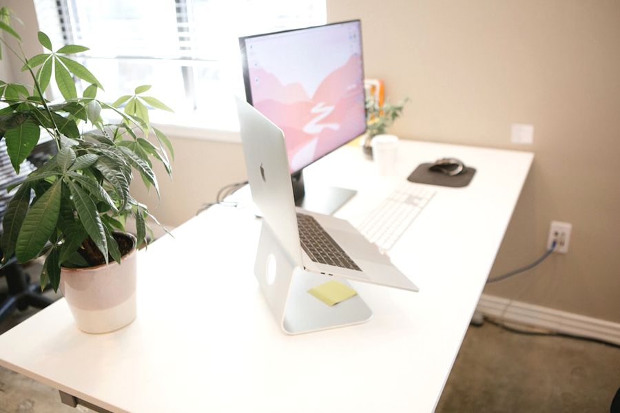Bright desk with a laptop and monitor by a window